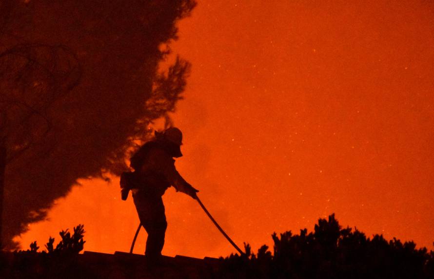 Firefighters battle a wind-driven wildfire called the Saddle Ridge fire in the early morning hours Friday in Porter Ranch
