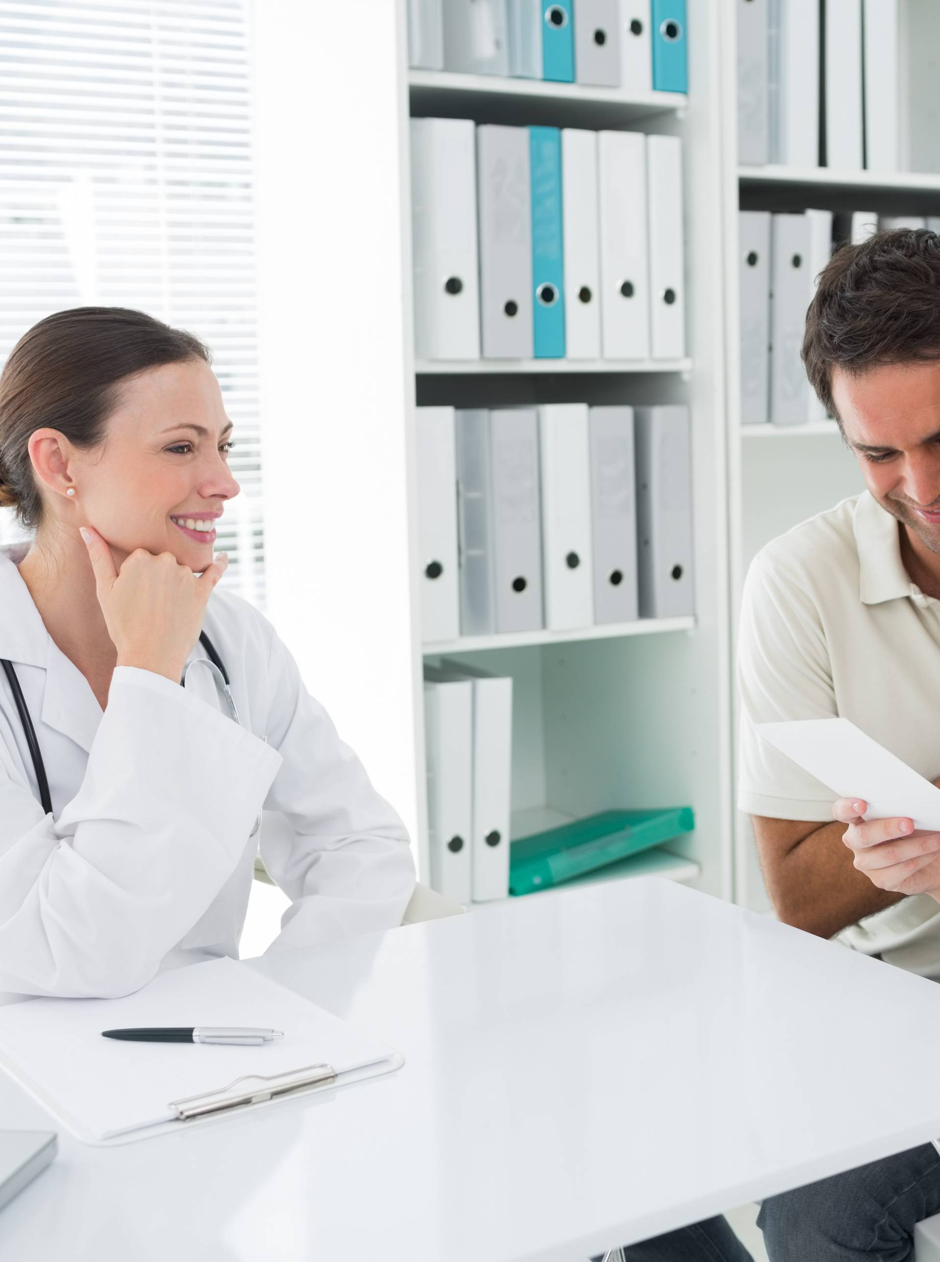 Expectant couple looking at reports in clinic