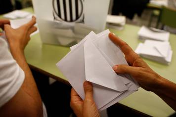 Poll workers count ballots after polls closed at a polling station for the banned independence referendum in Barcelona