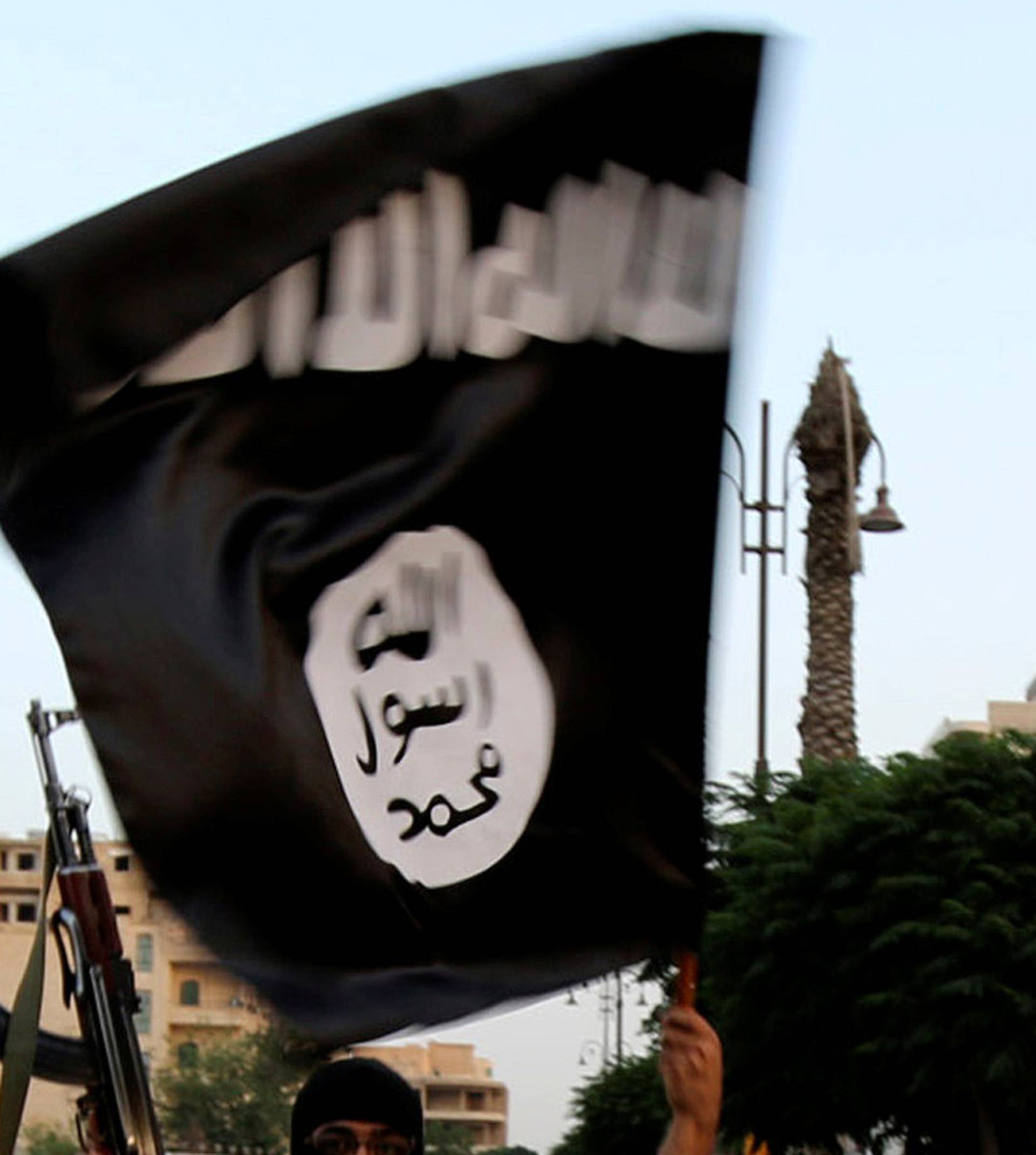FILE PHOTO: A member loyal to the ISIL waves an ISIL flag in Raqqa