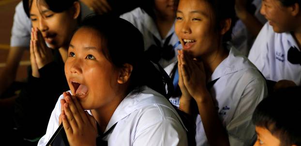 Classmates pray after their teacher announced some of the 12 schoolboys trapped inside a flooded cave, have been rescued, at Mae Sai Prasitsart school, in the northern province of Chiang Rai