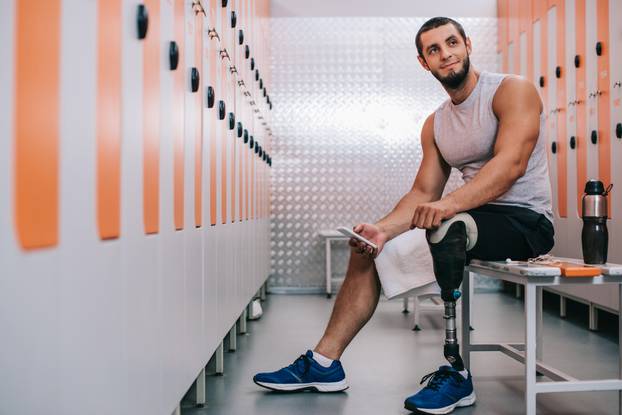 Smiling,Young,Sportsman,With,Artificial,Leg,Sitting,On,Bench,At