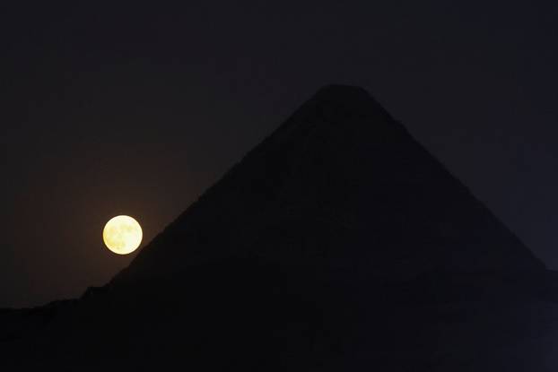 Full moon rises behind the Pyramids of Giza in Egypt