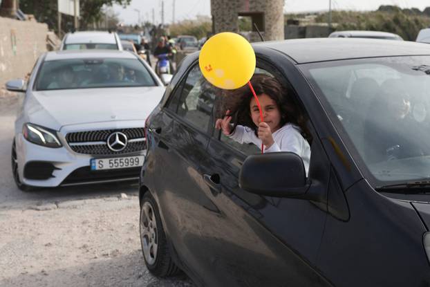 Displaced people cross the bridge linking southern Lebanon to the rest of the country, which was hit earlier in an Israeli strike, in Qasmiyeh