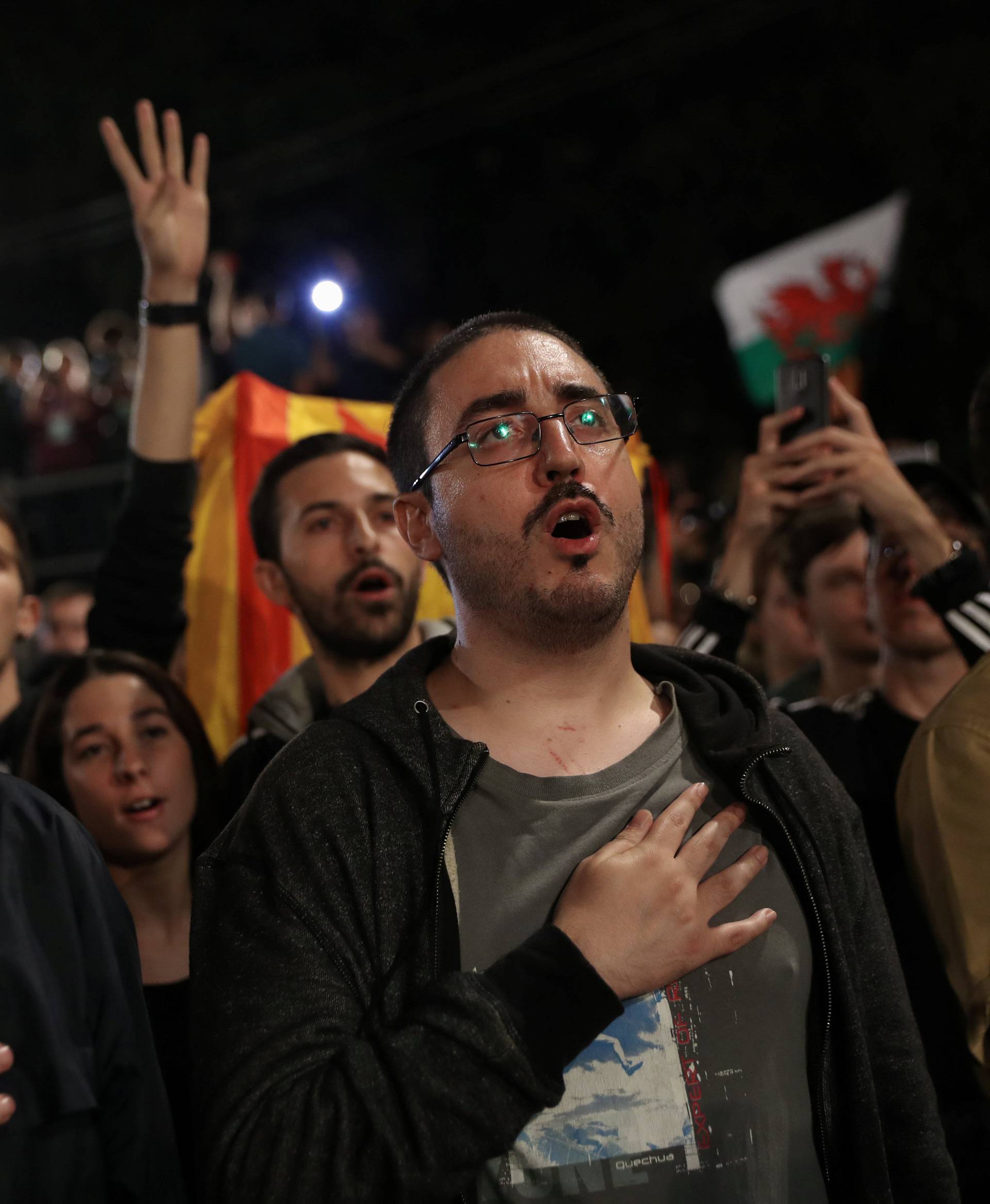 People sing during a gathering at Plaza Catalunya after voting ended for the banned independence referendum, in Barcelona