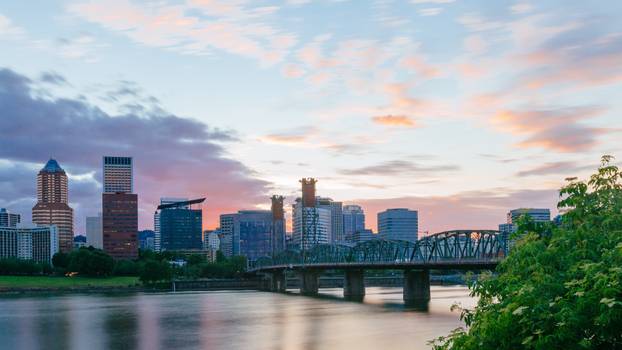 Hawthorne Bridge over Willamette River at sunset with skyline of