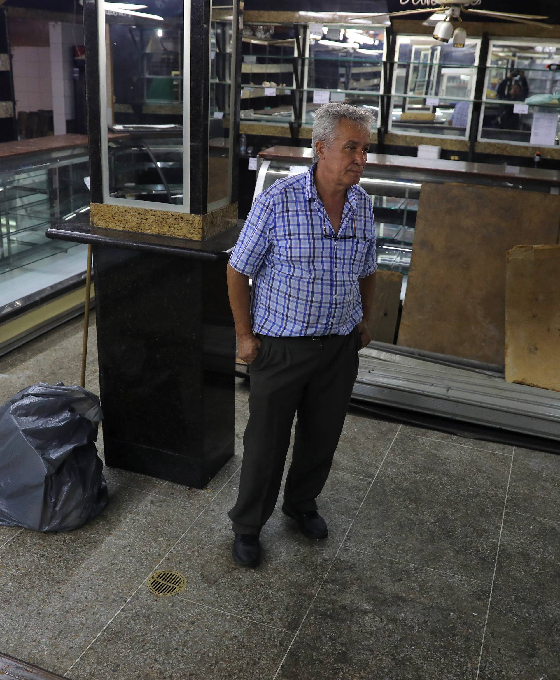 Manuel Fernandes, a local businessman, stands inside of his bread and cake shop after looters broke in, following days of protest against Venezuelan President Nicolas Maduro in the city of Los Teques