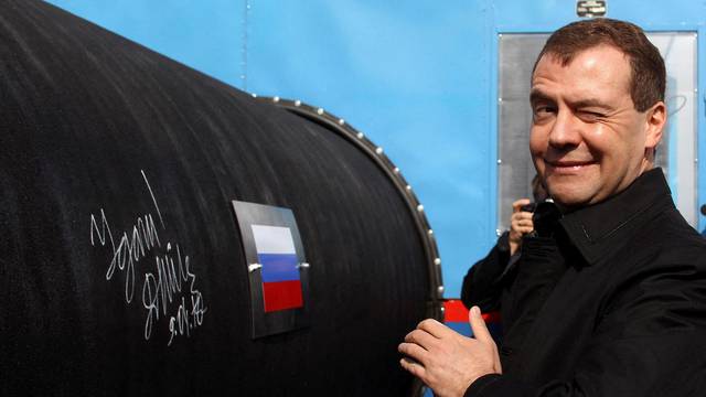 FILE PHOTO: Russian President Medvedev gestures after writing 'Good Luck!' on a pipe of the Nord Stream pipeline near Russian town of Vyborg