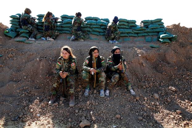Iranian-Kurdish female fighters hold their weapons during a battle with Islamic State militants in Bashiqa, near Mosul