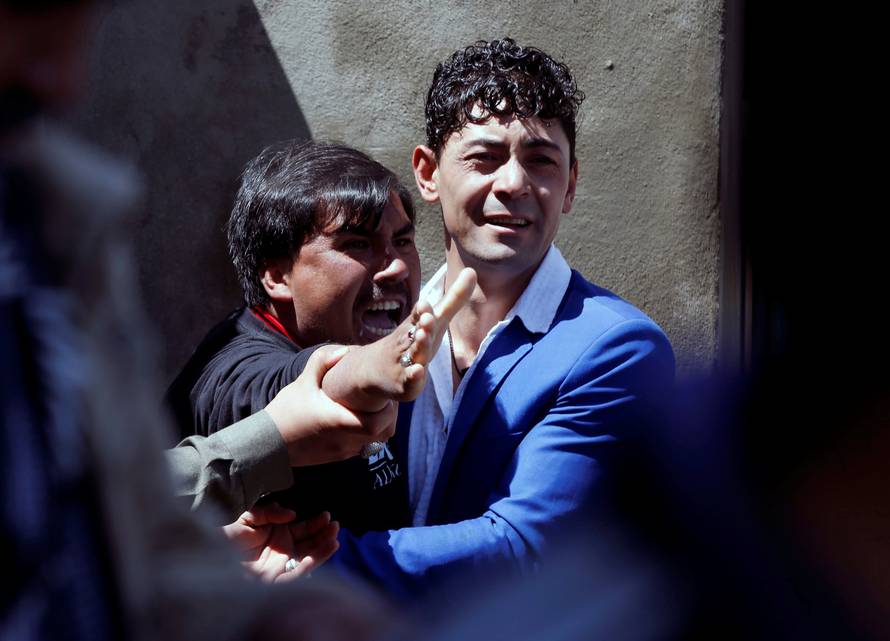 A man reacts as others comfort him at the site of a suicide attack in Kabul