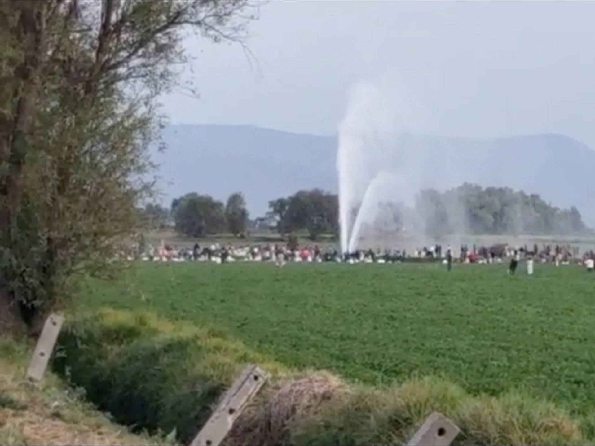 People gather at the site of a ruptured pipeline in the municipality of Tlahuelilpan, in Hidalgo