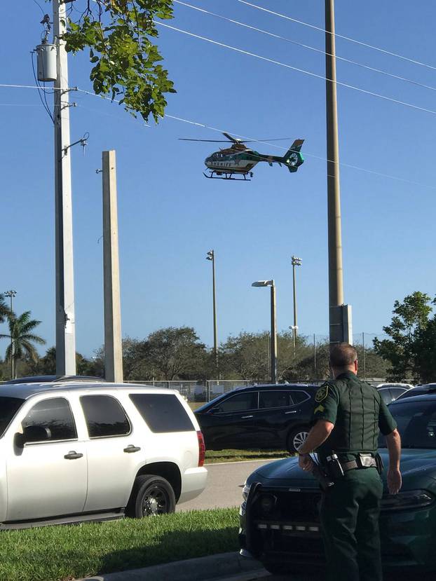 Police cars and a helicopter are seen in Coral Springs after a shooting at the Marjory Stoneman Douglas High School in Parkland