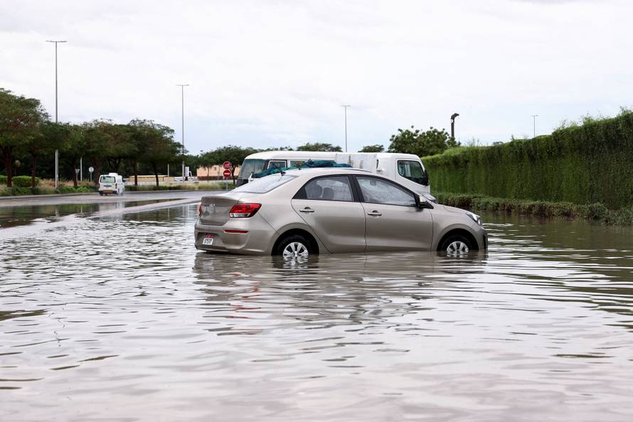 Parked cars stand in flood water following heavy rains in Dubai