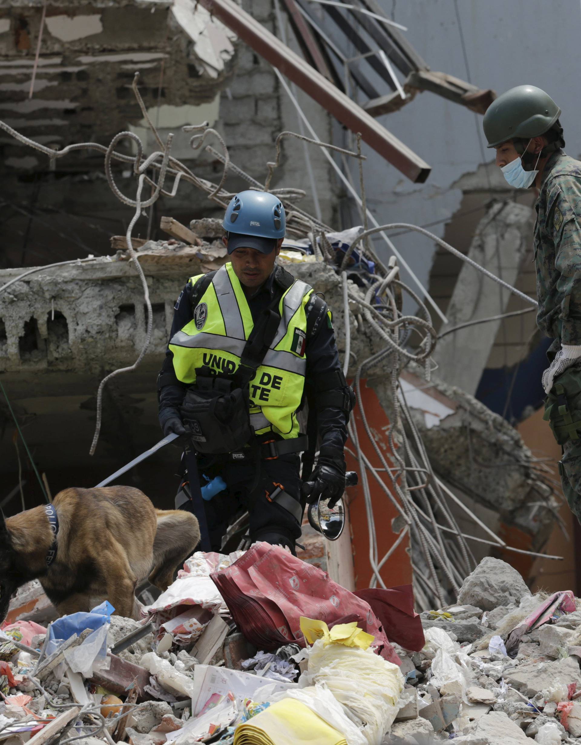 Mexico's Federal police officers and a Ecuadorean soldier search for victims amidst debris of collapsed buildings in Manta
