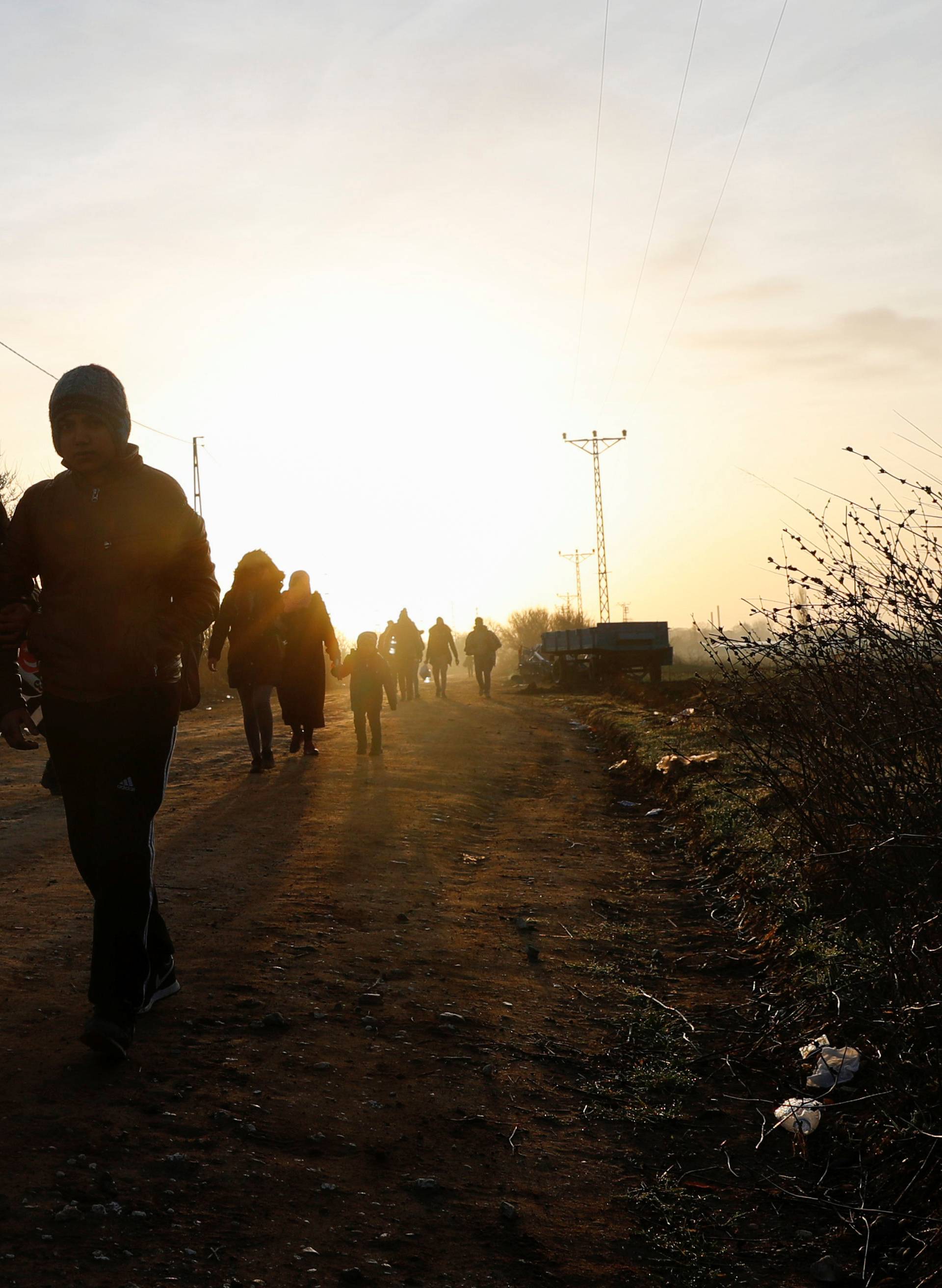 Migrants walk next to the Turkey's Pazarkule border crossing with Greece's Kastanies, near Edirne