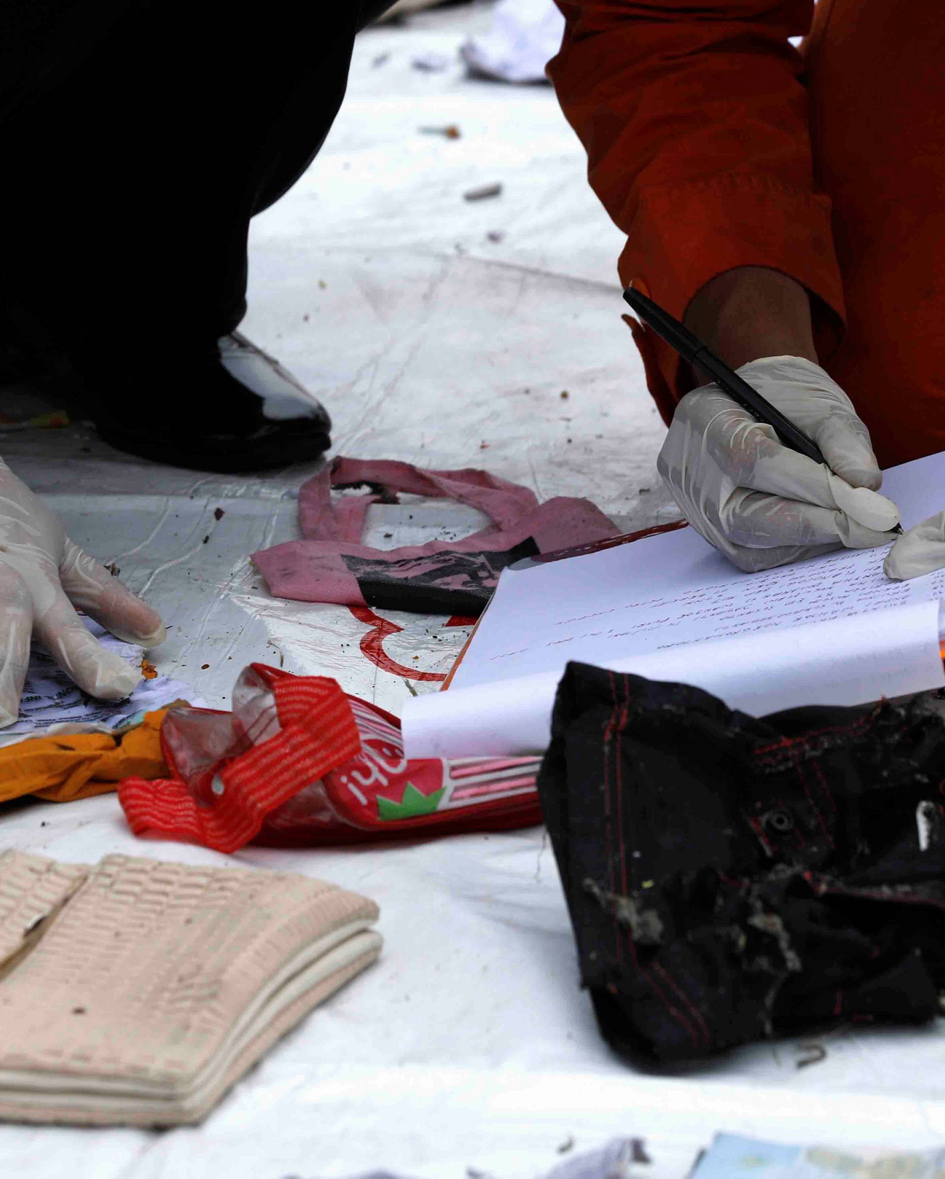 Police personnel identify recovered belongings believed to be from the crashed Lion Air flight JT610 at Tanjung Priok port in Jakarta