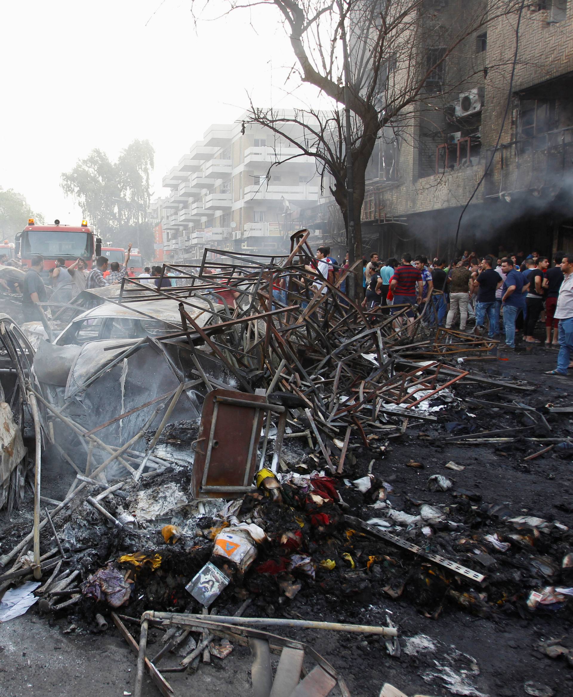 People gather at the site of a suicide car bomb in the Karrada shopping area, in Baghdad, Iraq 