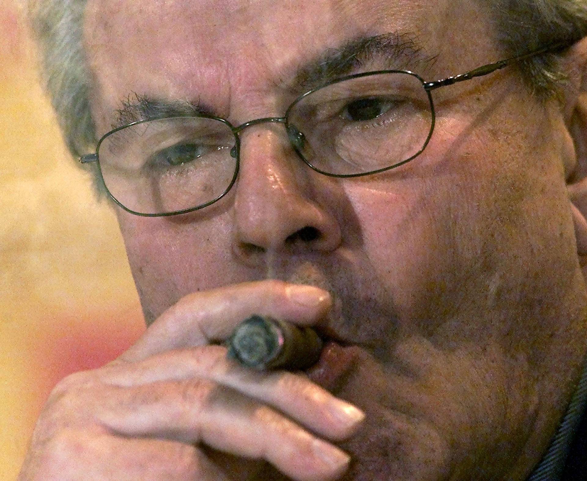 FILE PHOTO: Czech film director Milos Forman smokes a cigar as he listens to journalists' questions during a new..