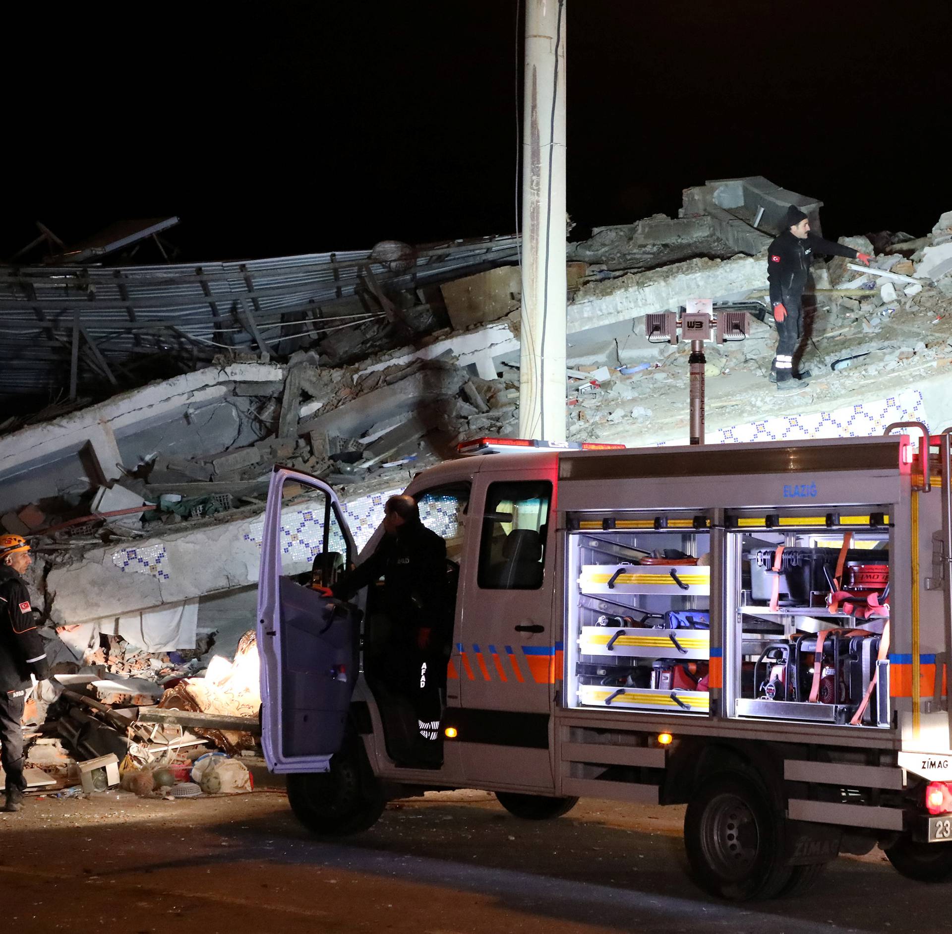 Rescue workers search on a collapsed building after an earthquake in Elazig