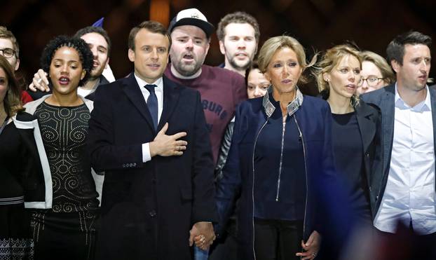 French President elect Emmanuel Macron and his wife Brigitte Trogneux celebrate on the stage at his victory rally near the Louvre in Paris