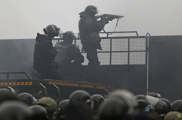 Kazakh law enforcement officers are seen on a barricade during a protest triggered by fuel price increase in Almaty