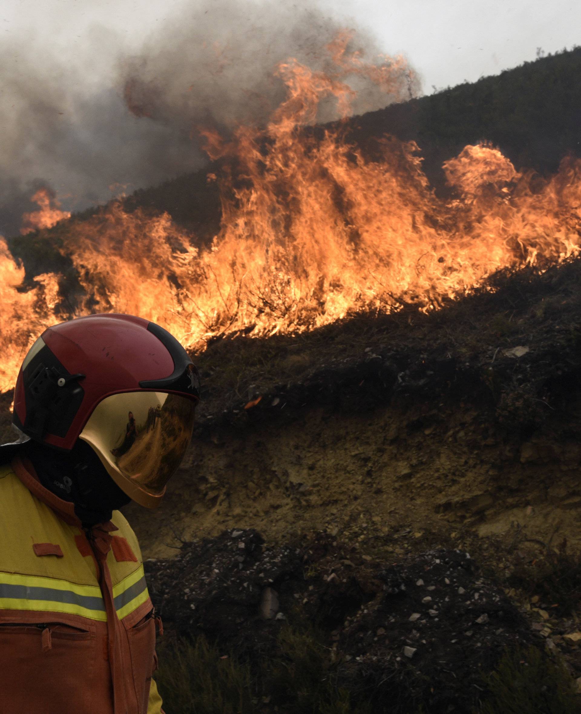 A firefighter stands near a firewall in Tablado, near Muniellos park, Asturias