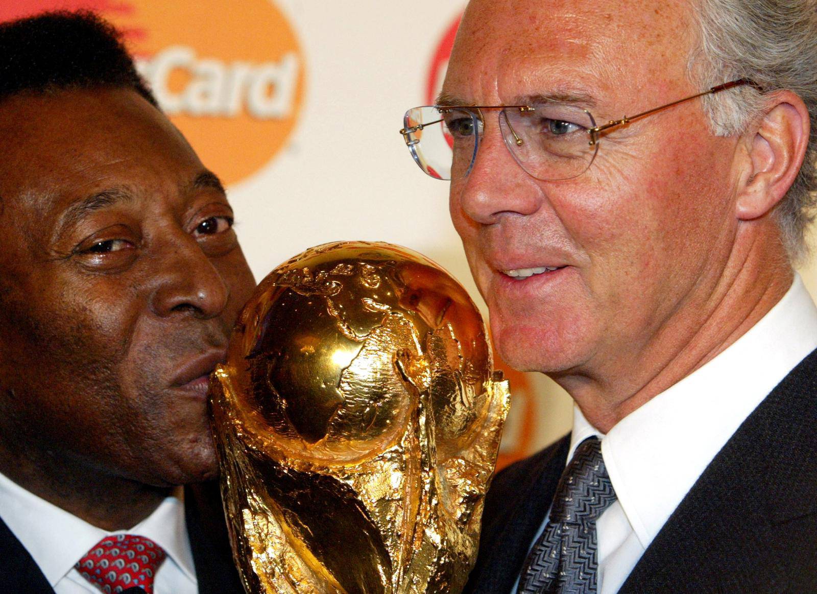 FILE PHOTO: Brazilian soccer legend Pele kisses world cup next to german legend Beckenbauer, in Berlin