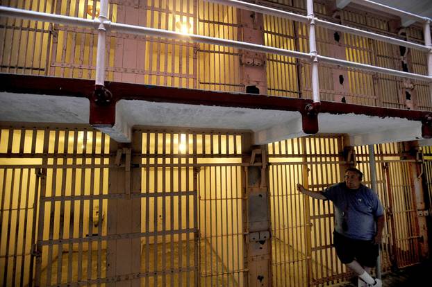 File Photo: A Visitor to Alcatraz Island's Former Federal Prison Leans Against A B Block Cell in the San Francisco Bay