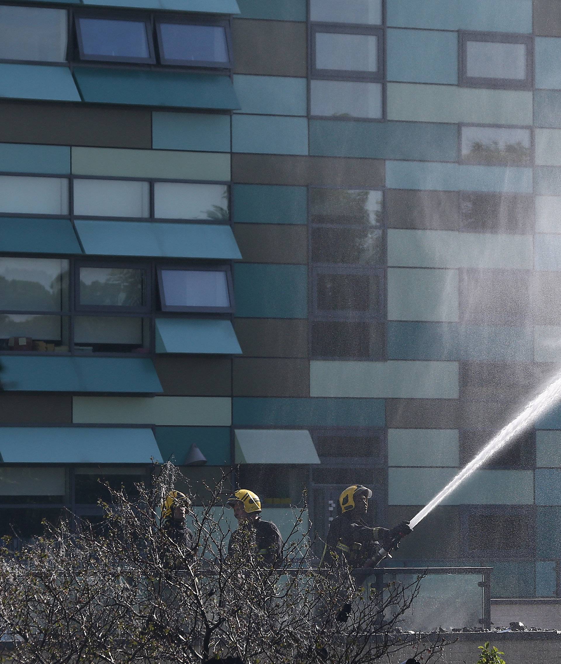 Firefighters direct jets of water towards a tower block severly damaged by a serious fire, in north Kensington, West London