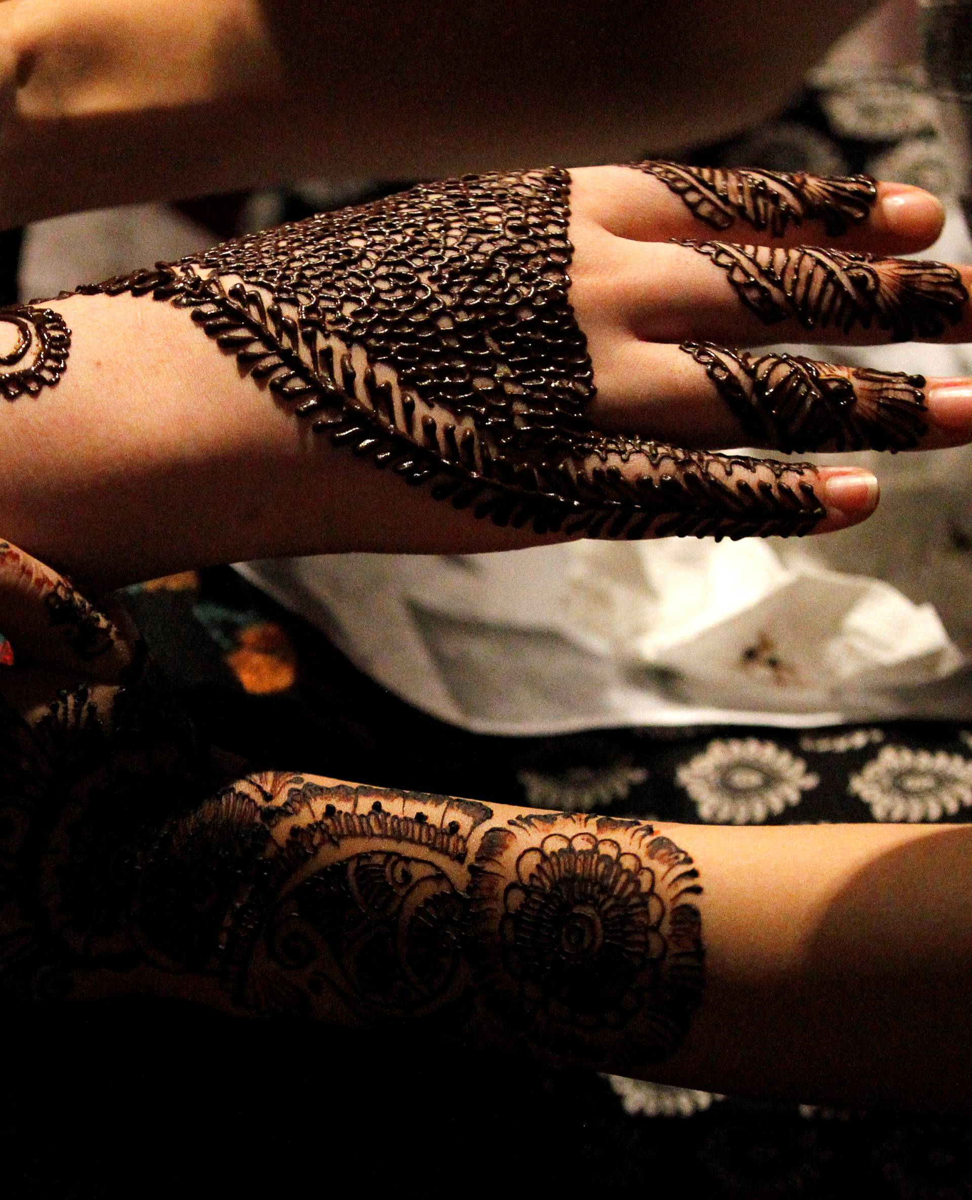 Women get Henna tattoos (Mehndi) ahead of Eid al-Fitr, which marks the end of the Muslim holy fasting month of Ramadan, at a market in Islamabad