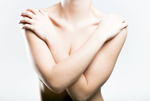 Woman covering her breasts arms