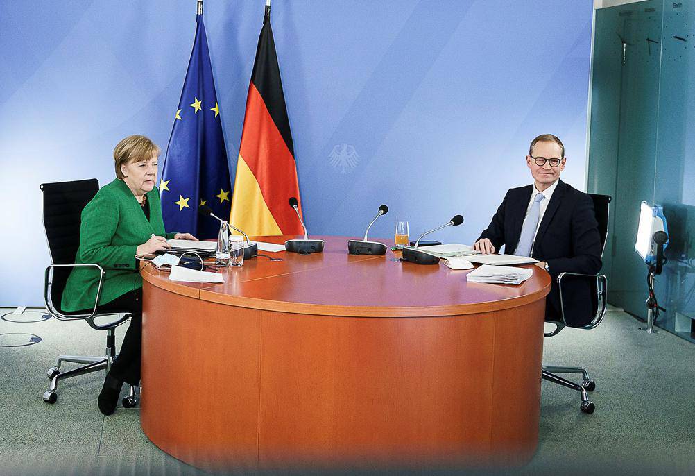 German Chancellor Angela Merkel and Berlin mayor Michael Mueller attend a video conference with state leaders at the Chancellery in Berlin