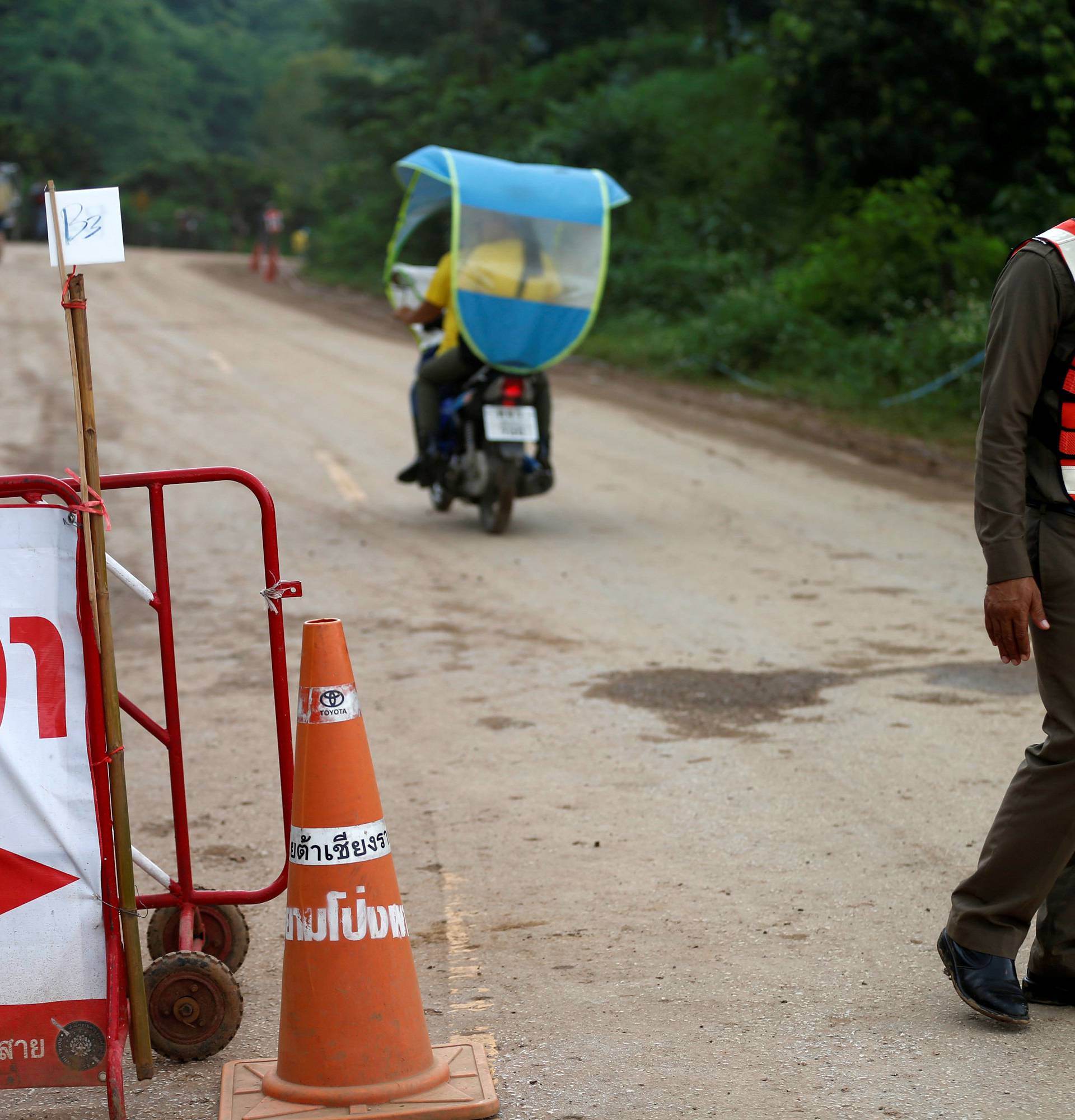 Police officers block a road leading to the Tham Luang cave complex in the northern province of Chiang Rai