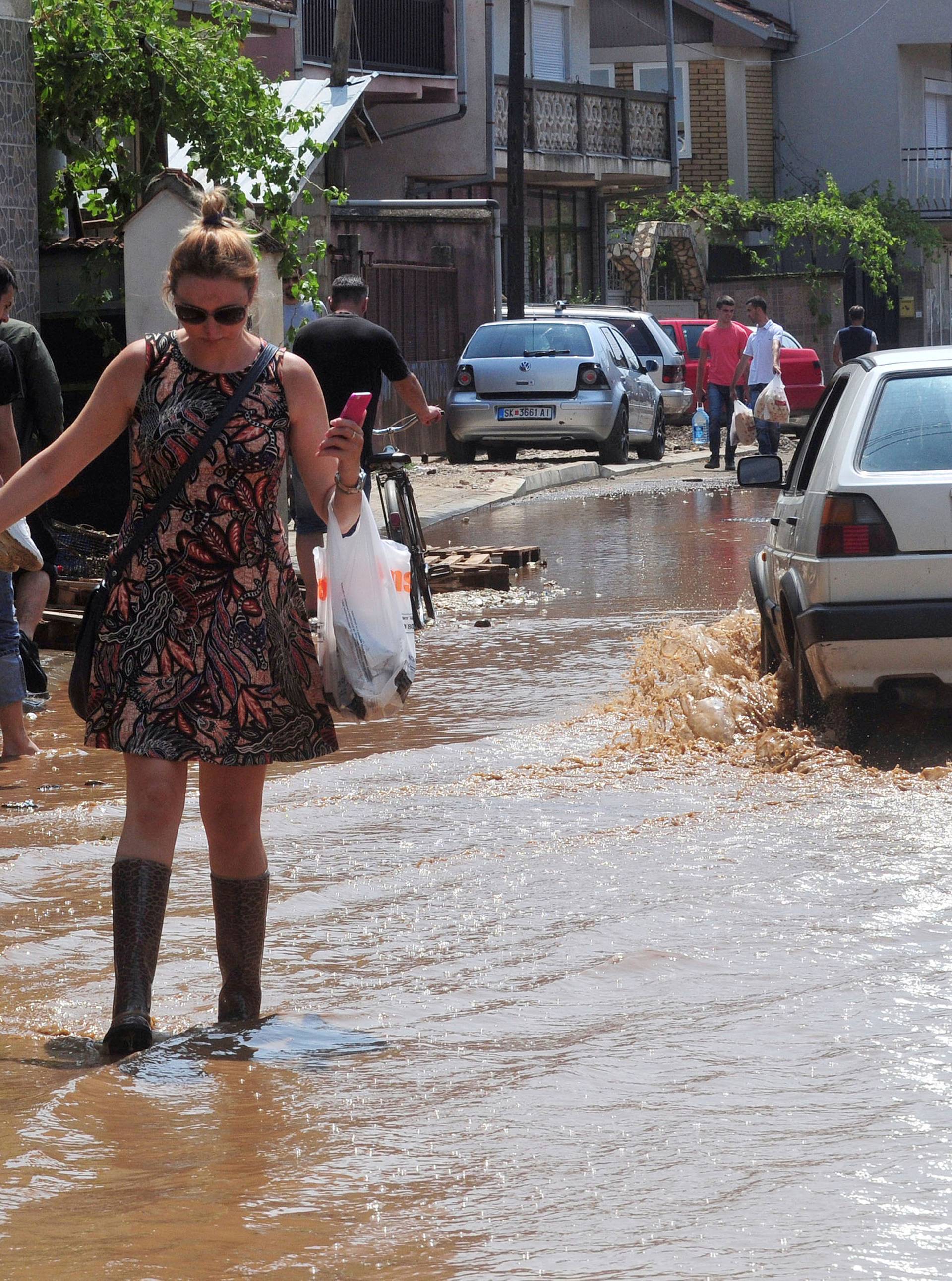 A woman wallks on the street after heavy floods in Cento 