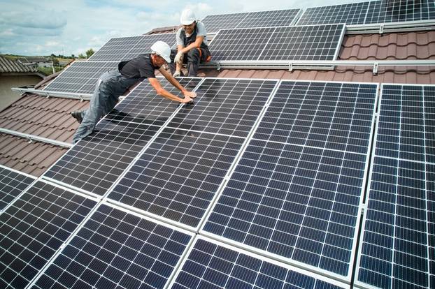 Men,Installers,Mounting,Photovoltaic,Solar,Moduls,On,Roof,Of,House.