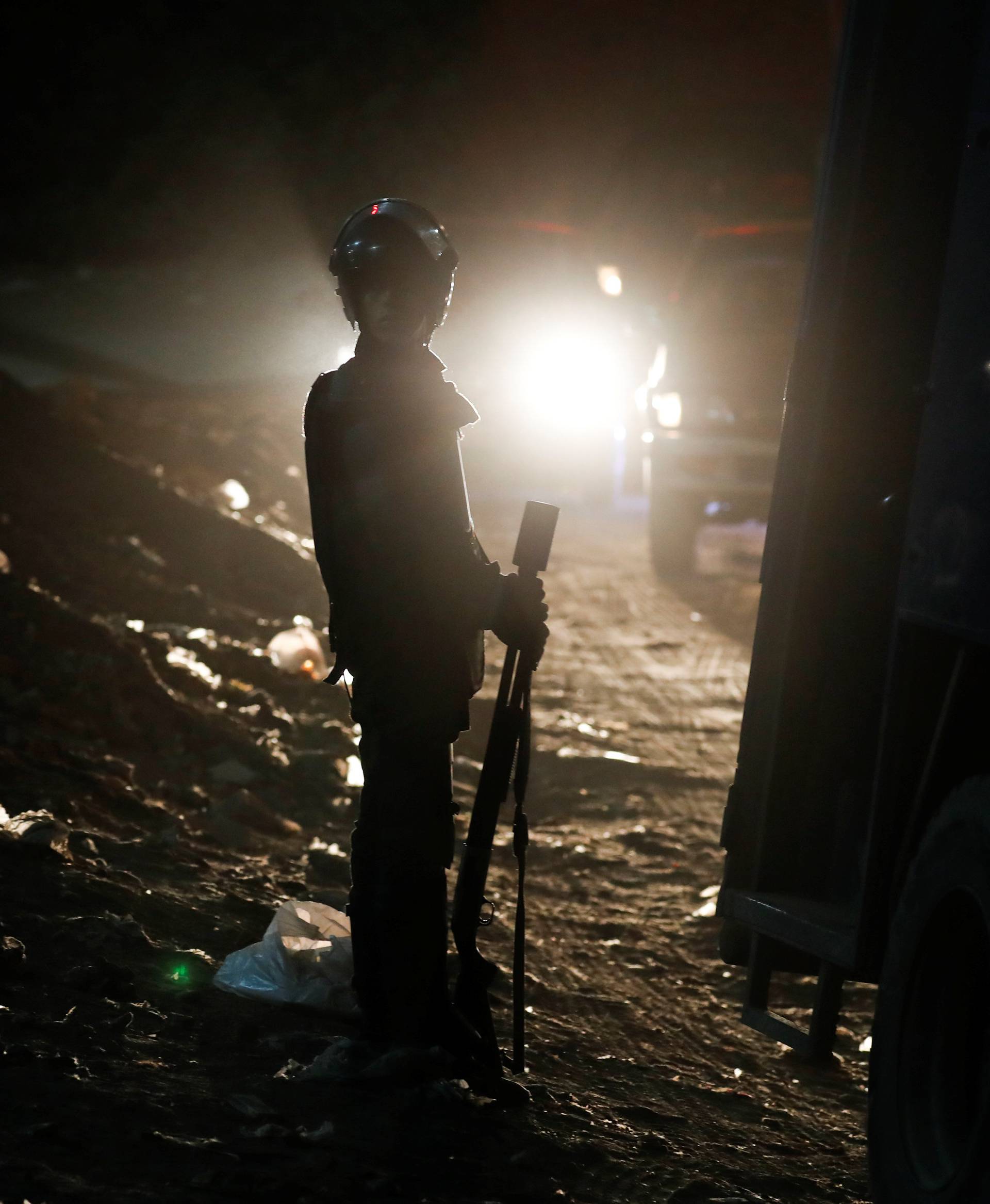 A riot policeman secures a scene of a bus blast in Giza