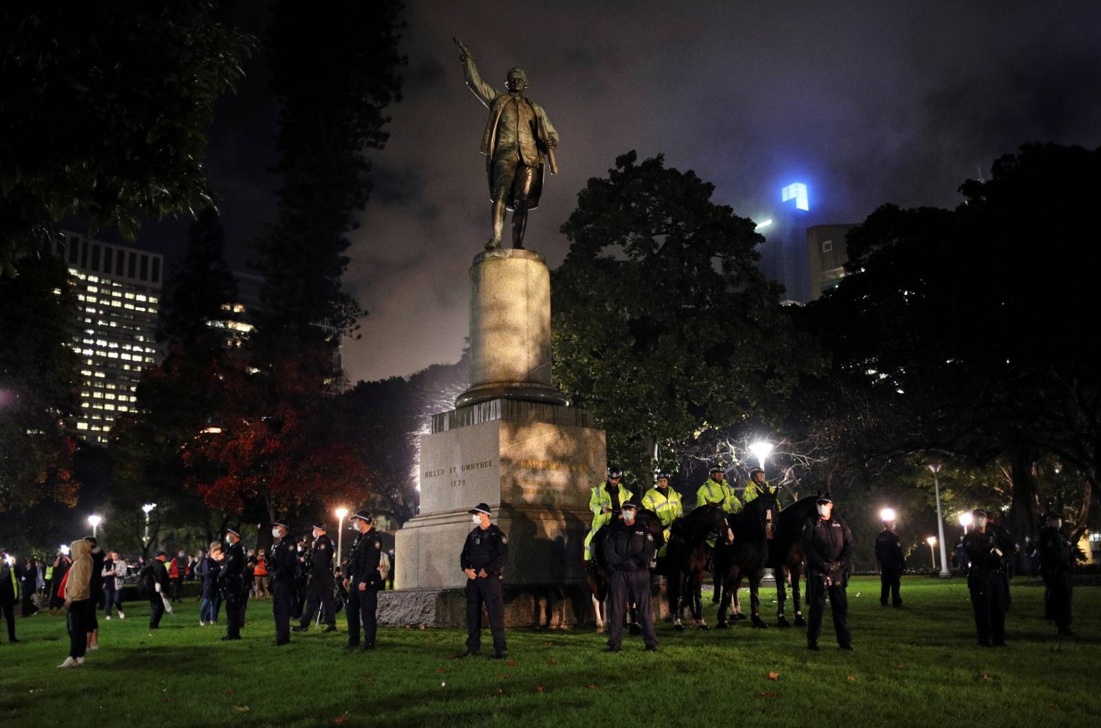 Police officers stand guard around the statue of British explorer Captain James Cook as they deter demonstrators from taking part in a protest in solidarity with the Black Lives Matter protests, in Sydney