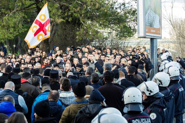 Serbian Orthodox Church clergy and believers hold a service on a bridge near the parliament, ahead of a vote for a bill on 