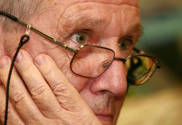 FILE PHOTO: Israeli novelist Oz listens to a question during a meeting with Russian writers in the Russian PEN centre in Moscow