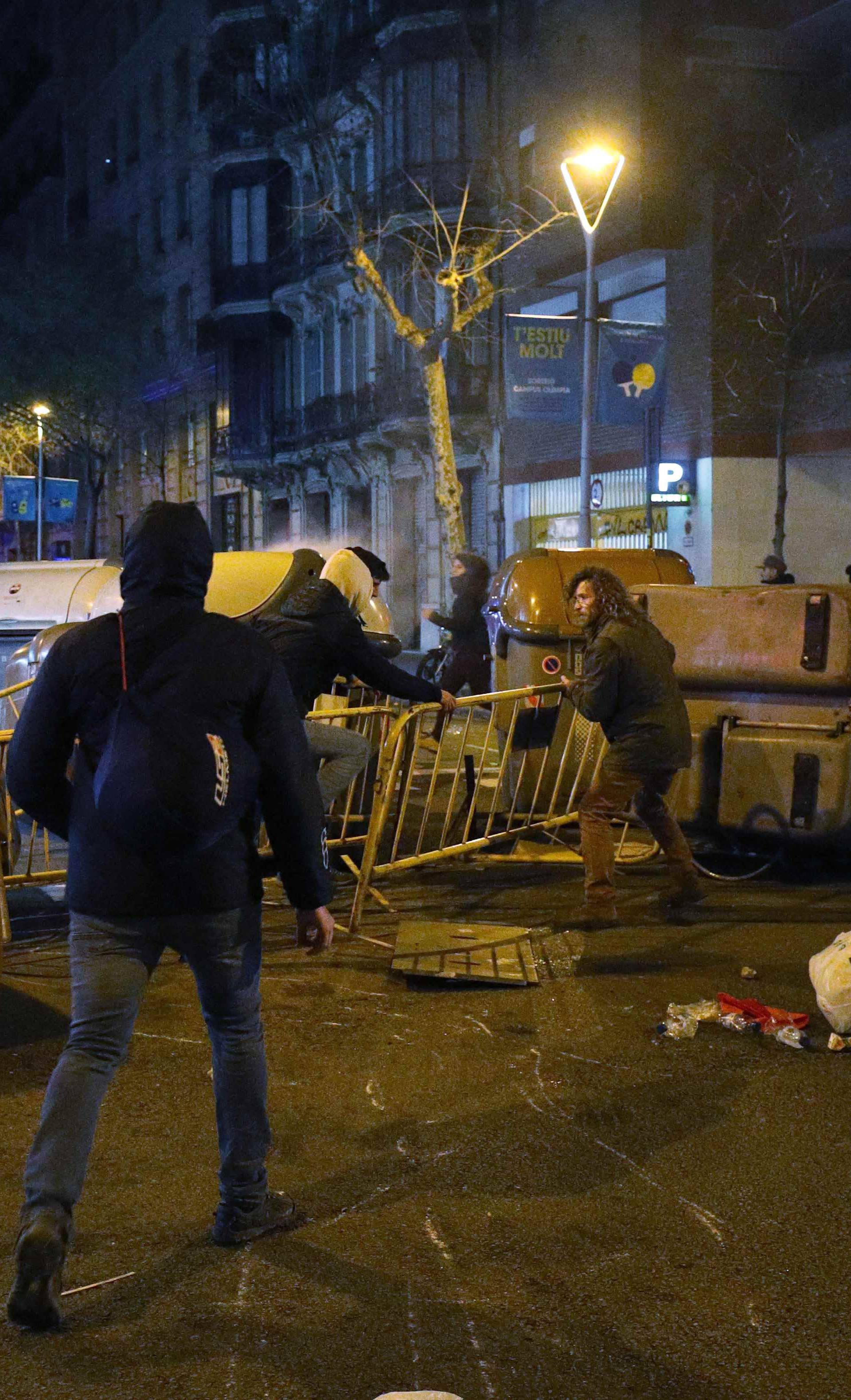 Protestors erect barricades on a street during skirmishes with police after former regional president Carles Puigdemont was detained in Germany,  in Barcelona