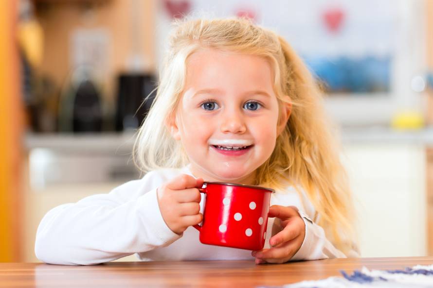 Girl drinking milk in kitchen