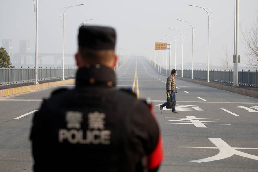 A man arriving from Hubei province approaches a checkpoint at the Jiujiang Yangtze River Bridge in Jiujiang