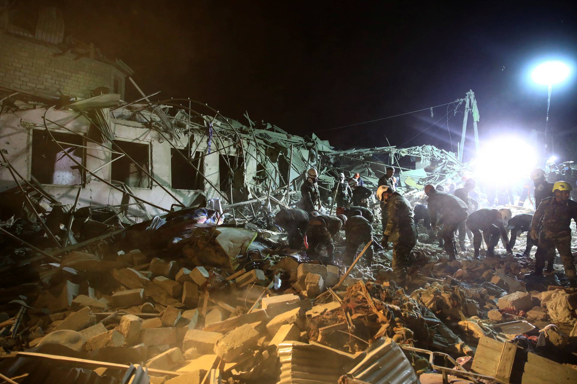 Search and rescue teams work on the blast site hit by a rocket in the city of Ganja