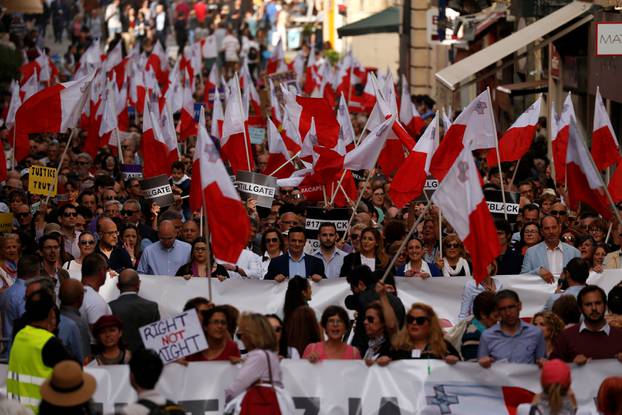 People carry Maltese flags during a protest against government corruption in light of the revelations in the Daphne Project, in Valletta