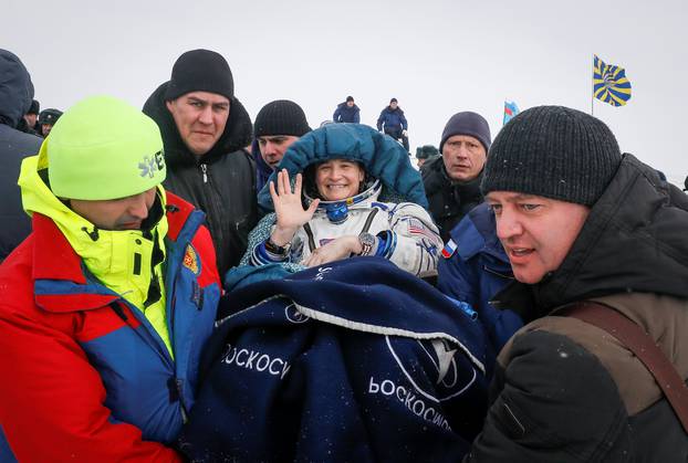 Ground personnel carry International Space Station crew member Aunon-Chancellor after landing near Zhezkazgan