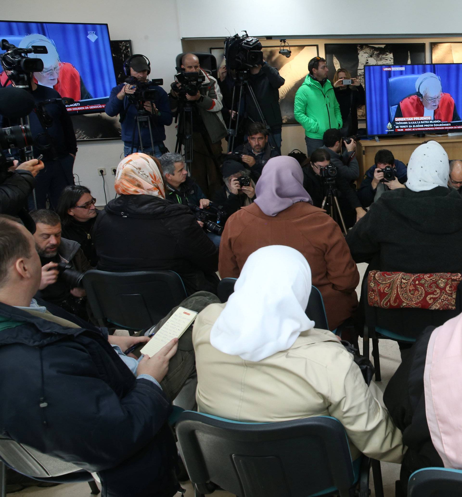 Victims and their family members watch a television broadcast of the court proceedings of former Bosnian Serb general Ratko Mladic in the Memorial centre Potocari near Srebrenica