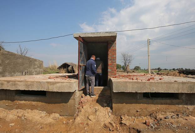 Workers get inside a concrete bunker after its construction in a residential area near the border with Pakistan in Samba sector