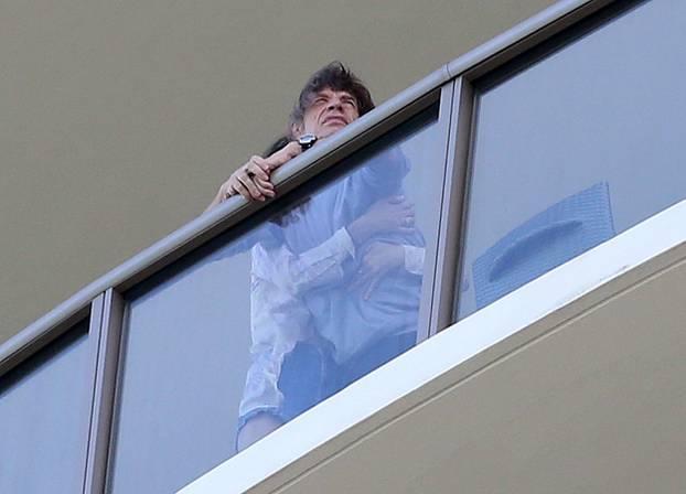 EXCLUSIVE: Mick Jagger is seen playing with his son and being comforted by his wife  Melanie Hamrick on their balcony in Miami