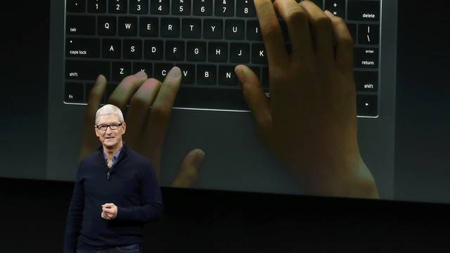 Apple CEO Tim Cook speaks under a graphic of the new MacBook Pro during an Apple media event in Cupertino