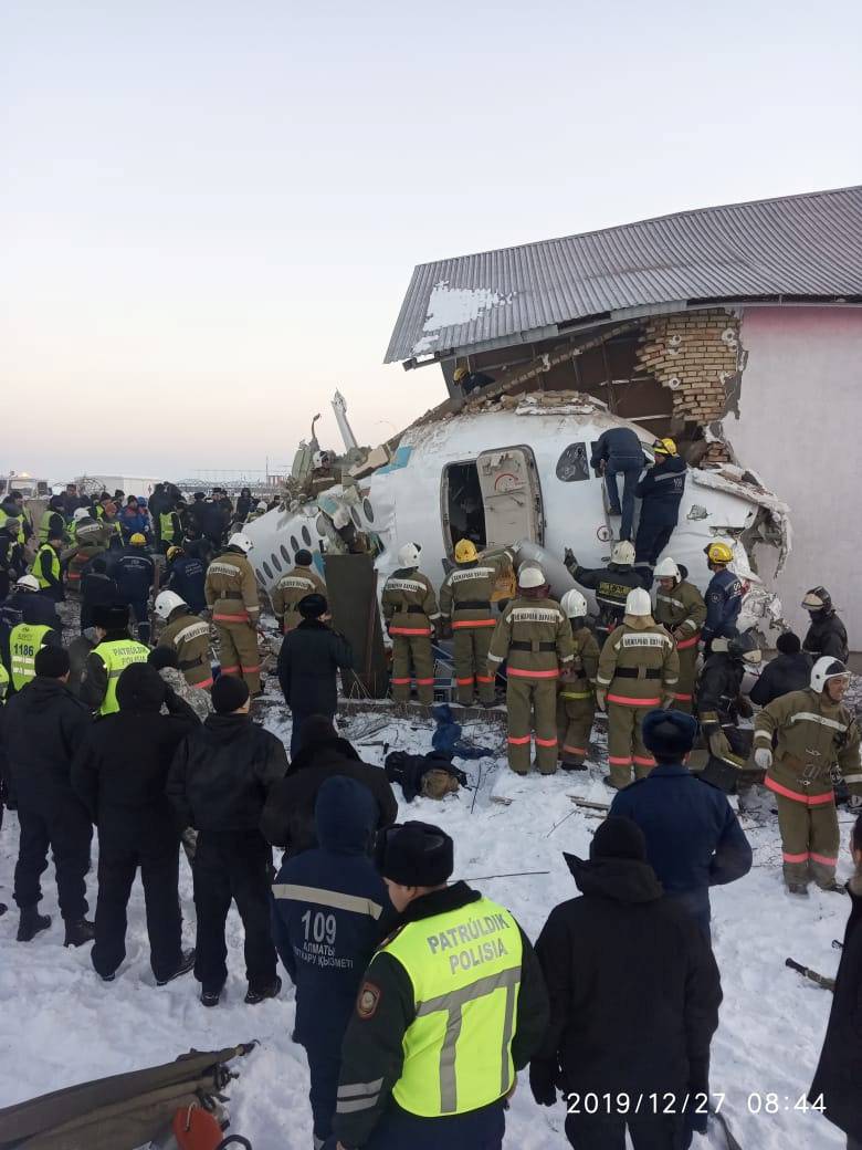 Emergency and security personnel are seen at the site of the plane crash near Almaty